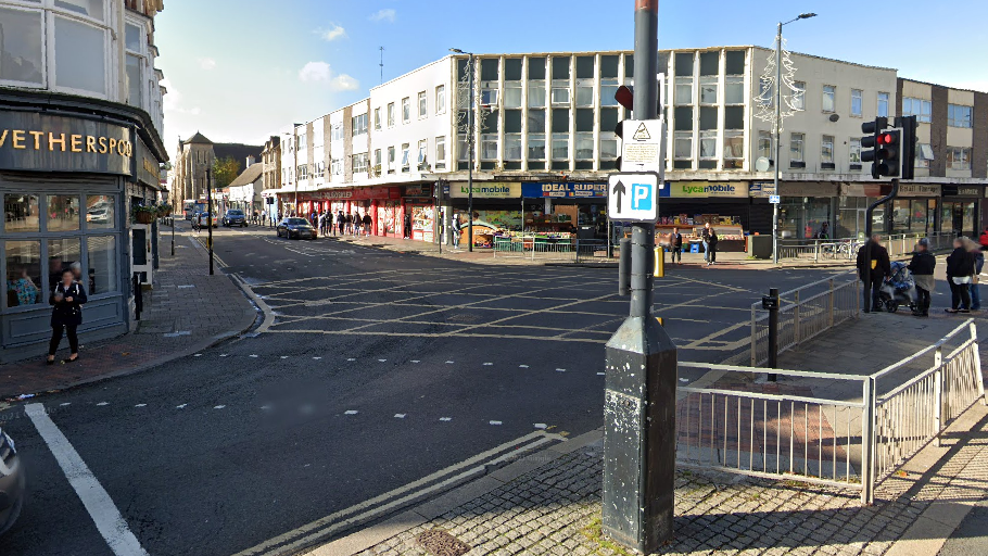 Junction of busy streets in the centre of Bedford showing traffic lights, road markings and buildings