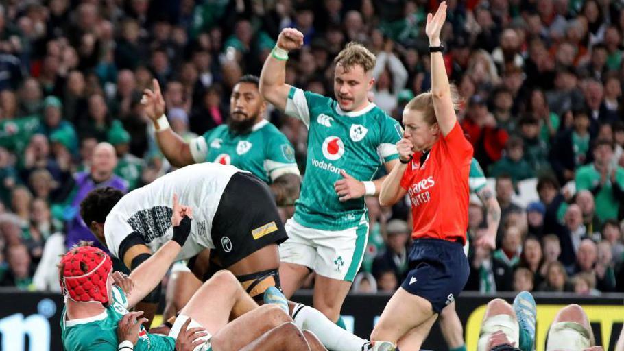 Referee Hollie Davidson indicates a second Irish try, scored by Ireland's flanker Josh Van der Flier (2L) during the Autumn International rugby union test match between Ireland and Fiji at the Aviva Stadium in Dublin, on November 23, 2024