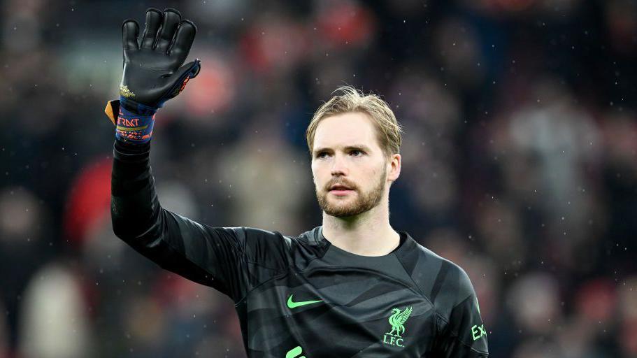 Caoimhin Kelleher of Liverpool raises his right hand