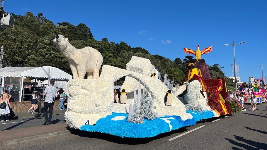 A float including a large polar bear, penguins a killer whale and a volcano