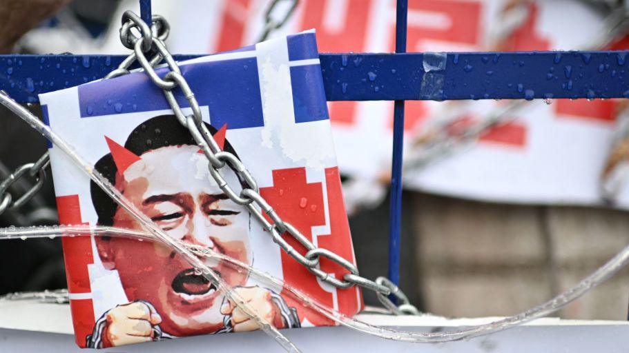 A poster of Yoon with chains and devil's horns displayed at an anti-Yoon protest