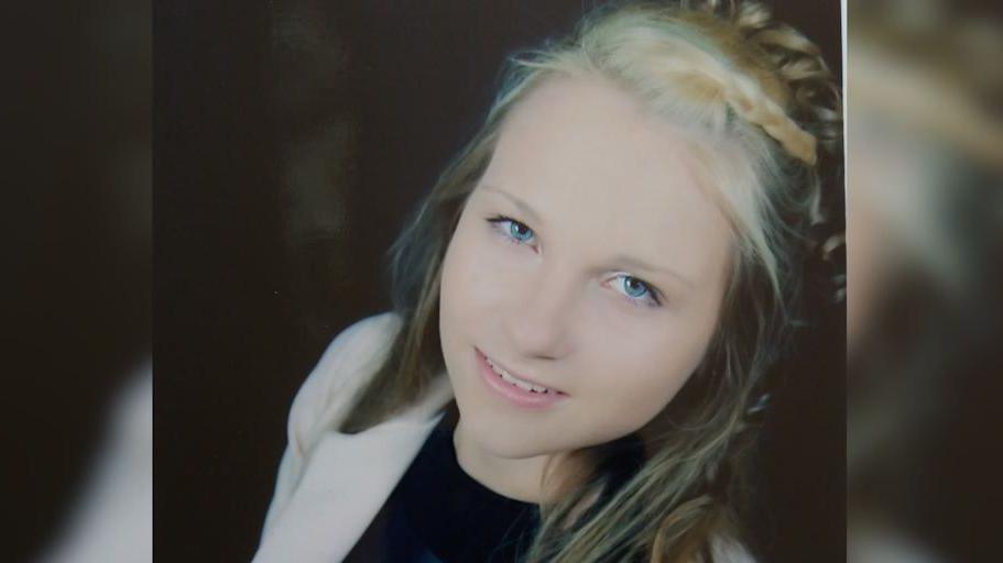 Simona Matukytnaite, who is wearing a cream jacket and black top. She has dark blond hair, partially in plaits, and is smiling at the camera.