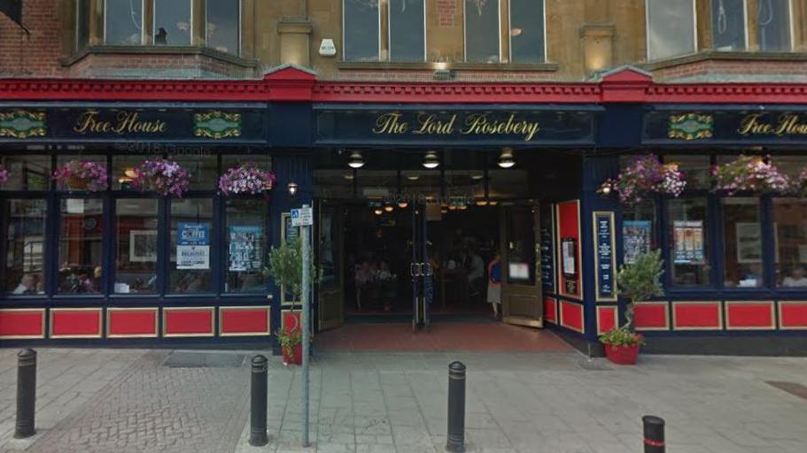 Large double-fronted pub with red and blue signs