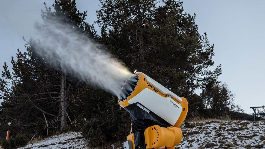 A snow cannon replenishes snow on the slopes at La Molina ski resort in Girona, Spain