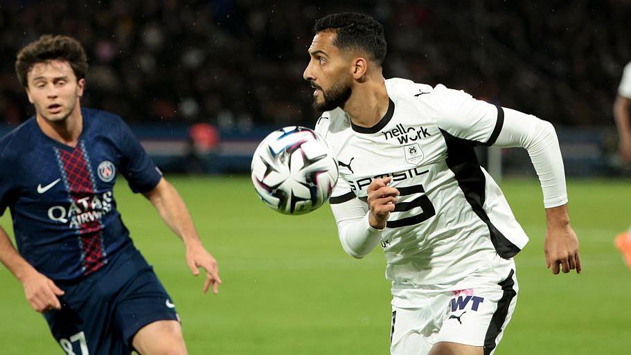 Musa Al-Taamari in action against PSG for Rennes in Ligue 1 during the 2025-26 season, chasing a ball while being watched by an opponent