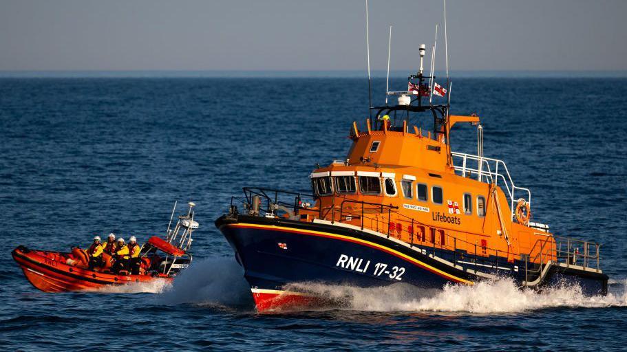 An RNLI lifeboat and an RNLI dinghy in the sea