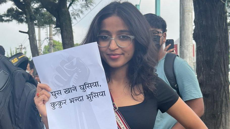 Tanuja Pandey holding a paper showing an anti-corruption slogan during the Gen-Z protests in Nepal 