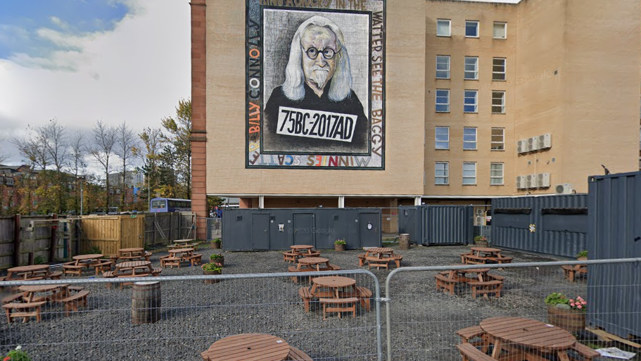 The building site with benches and portable toilets set up.