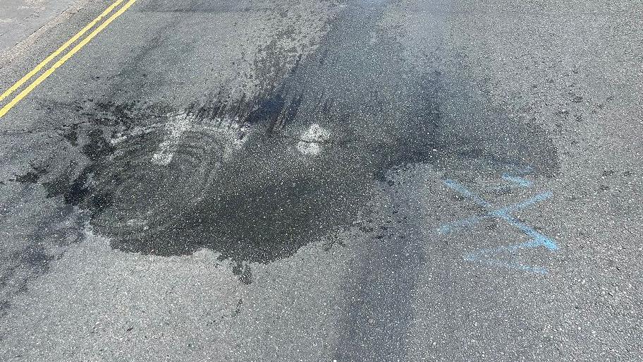 View of the dip in Cromer Road showing a blue painted X and a wet patch.
