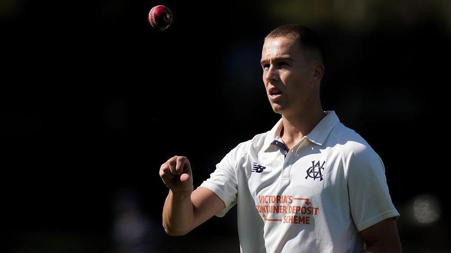 Pace bowler Mitch Perry tosses a ball up in the air as he walks back to his mark.