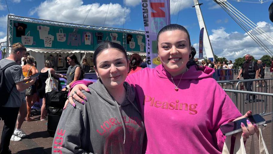 Two fans with their merchandise 