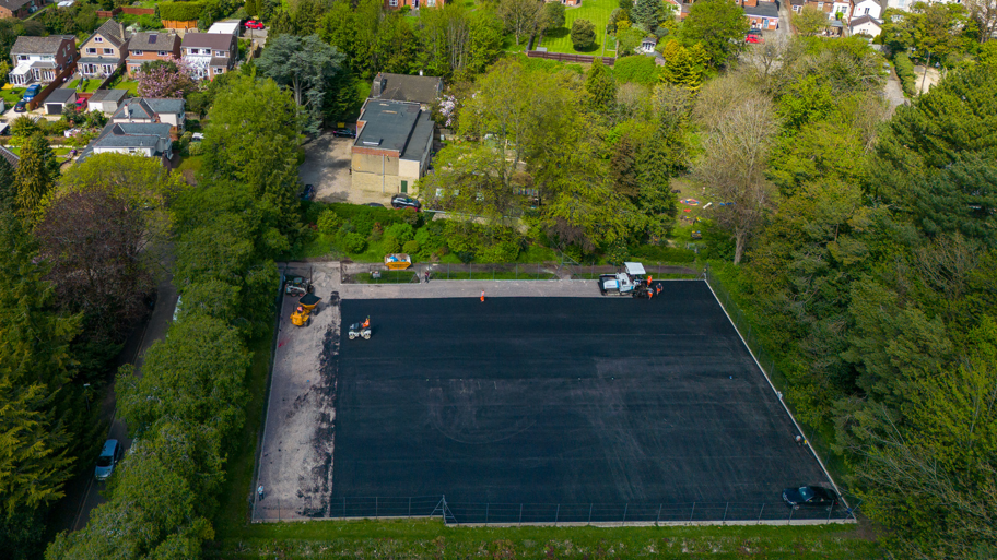 Quarry Road Tennis Courts having drainage work done. They are shown from high up with trees and houses visible in the background