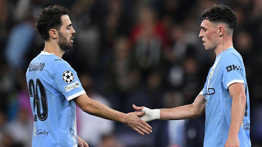 Image of Bernardo Silva and Phil Foden shaking hands during a match.