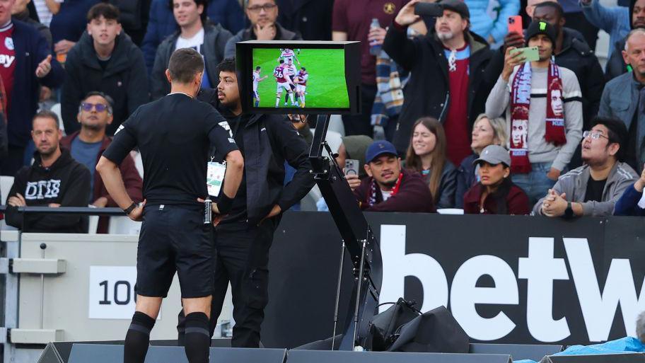 Referee David Coote checks a penalty decision on the VAR screen before awarding a penalty to West Ham United during the Premier League match between West Ham United FC and Manchester United FC at London Stadium on October 27, 2024