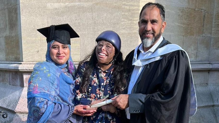 Shamiam Arif pictured after her graduation ceremony hold her degree certificate while her mother wear her mortar board and her father wears her gown