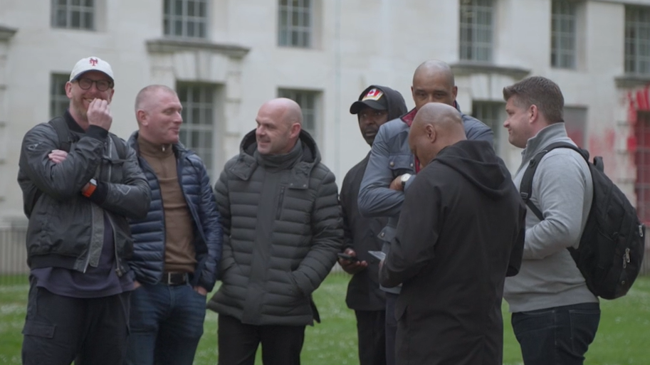 Footballers, including Tommy Johnson, Danny Murphy, Andy Cole and Brian Deane, stand together talking in Westminster. 