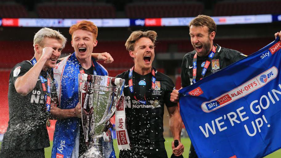 Four Northampton Town players celebrate winning the 2020 League Two play-off final. 