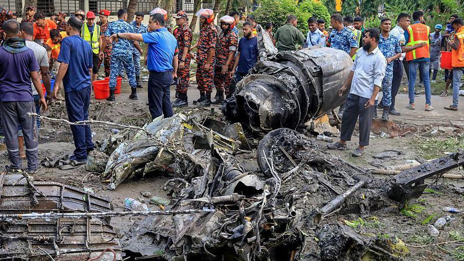 Bangladesh's fire service and security personnel conduct a search and rescue operation after an Air Force training jet crashed into a school in Dhaka