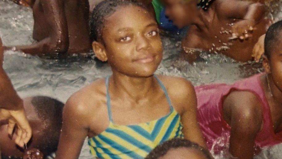 A young Libianca in a swimming pool with other children in Bamenda