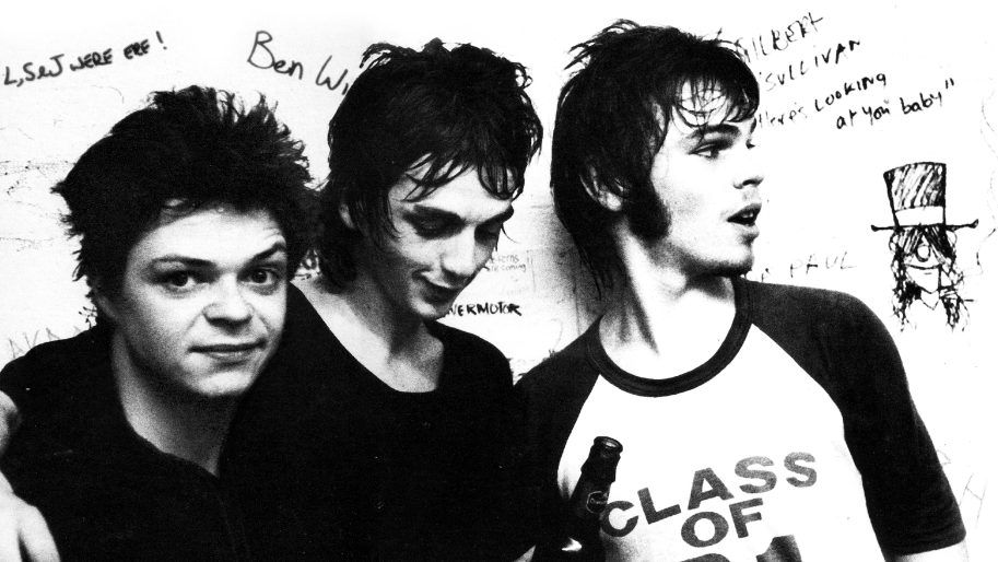 A stylised black and white press shot of the Kaiser Chiefs with a white background covered in graffiti-style writing