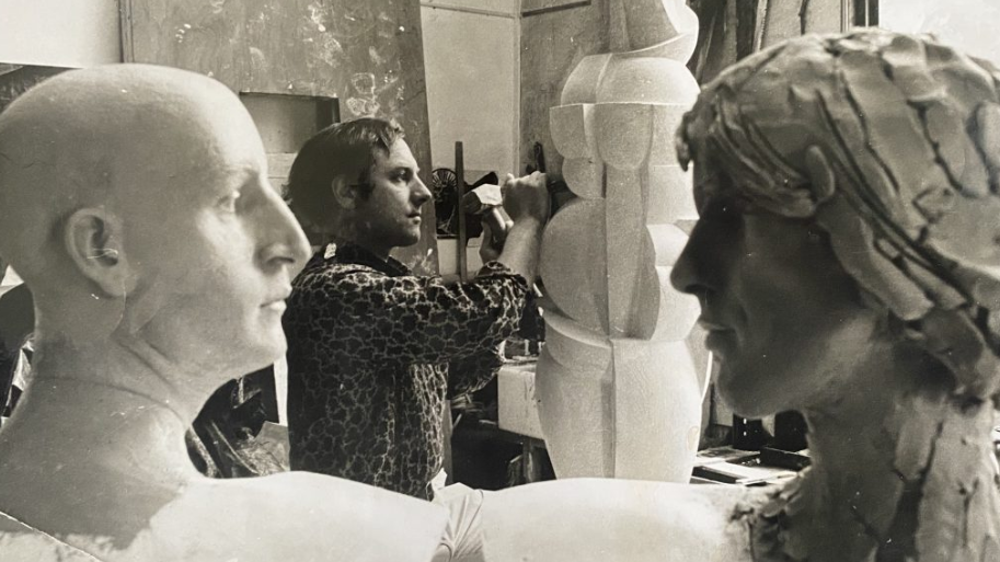 Black and white photo of James Butler in his home studio working on a sculpture.