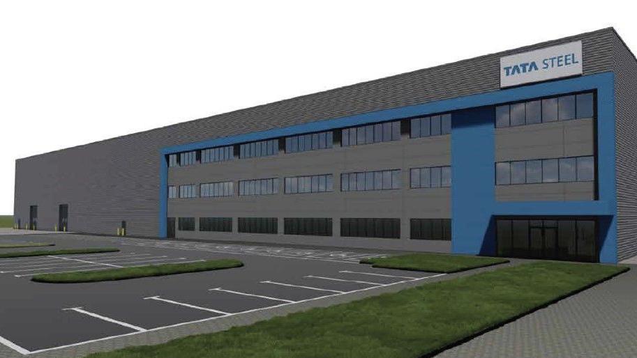 Grey three-storey warehouse building with parking spaces in foreground