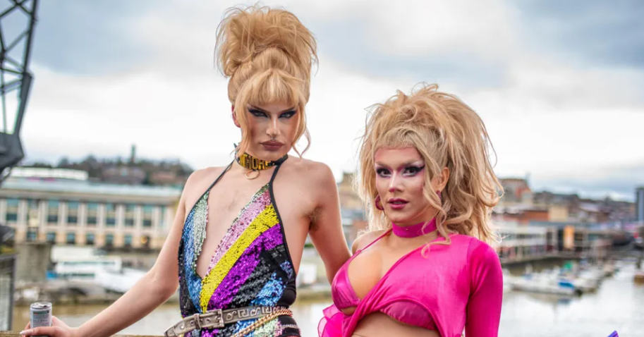 Venus Wailer in pink drag clothes standing in front of Bristol harbourside.