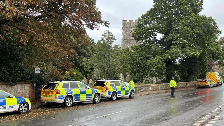 Five police vehicles and two police officers outside of St Martin's church in Overstrand.