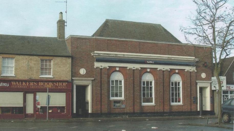 Colour photo from 2005 shows the Georgian style façade of the NatWest building on the right and a book shop called 'Walkers' on the left. You can see a NatWest sign above the three arched windows and imposing doorways at each end of the building.