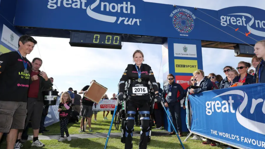 Claire Lomas, on crutches and wearing a robotic suit to brace her lower body, crosses the finish line for the Great North Run  