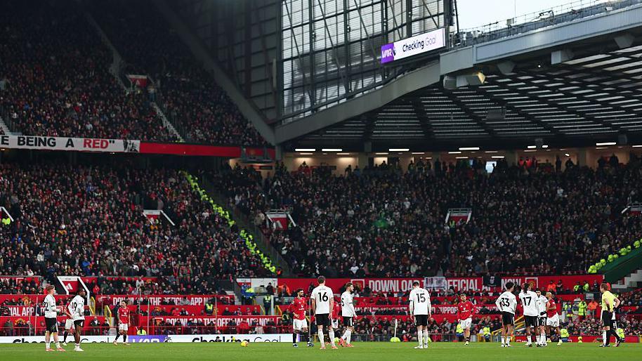 Manchester United and Fulham players wait for a VAR check on a goal