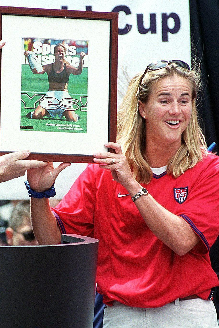 Brandi Chastain holds a framed copy of the Sports Illustrated cover featuring her picture