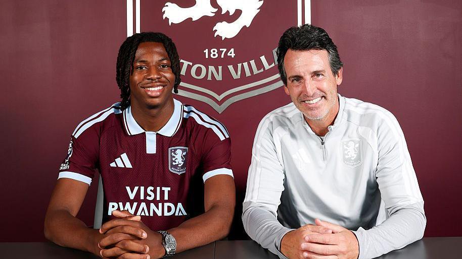 Johan Manzambi wears his Aston Villa shirt and sits with Unai Emery