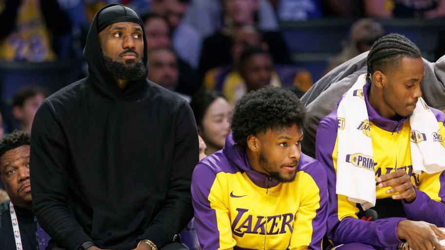 LeBron James and son Bronny on the LA Lakers bench during Sunday's game against the Portland Trail Blazers