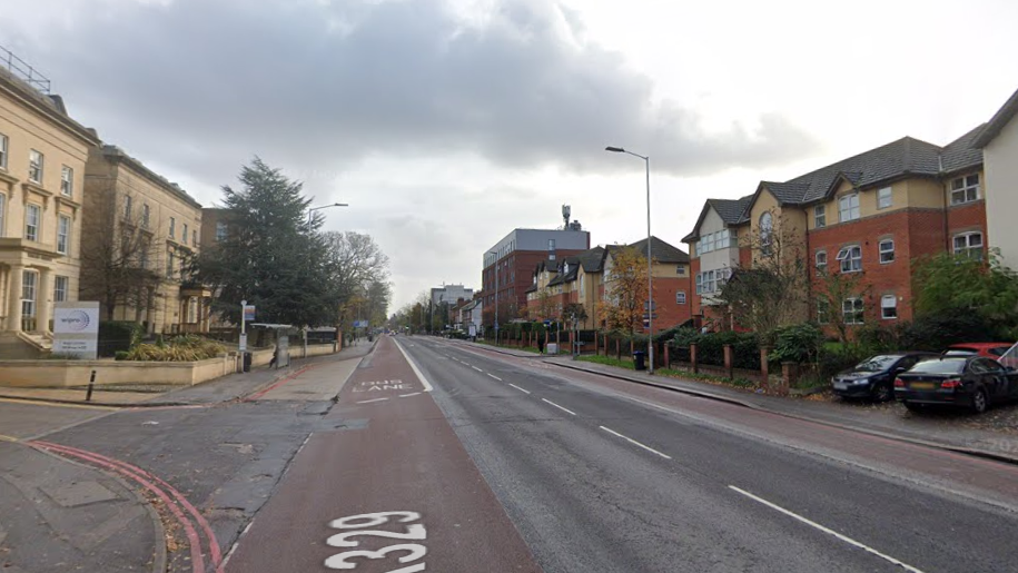 An empty stretch of road with buildings on both sides