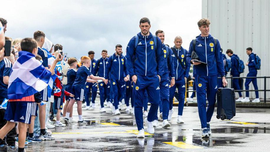 Scott McKenna and Jack Hendry make their way towards the plane at Glasgow Airport