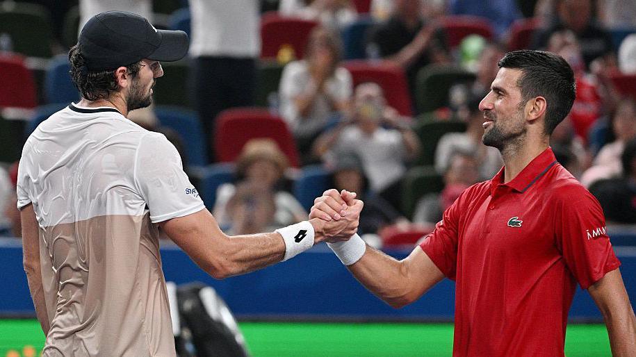Valentin Vacherot shakes hands with Novak Djokovic