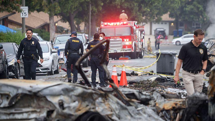 Investigators look through the site ehere a small plane crashed into San Diego, California