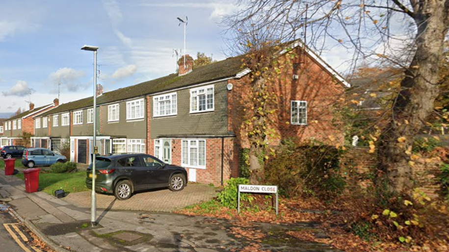 A row of terraced two-storey houses in Maldon Close. Cars are parked in driveways.