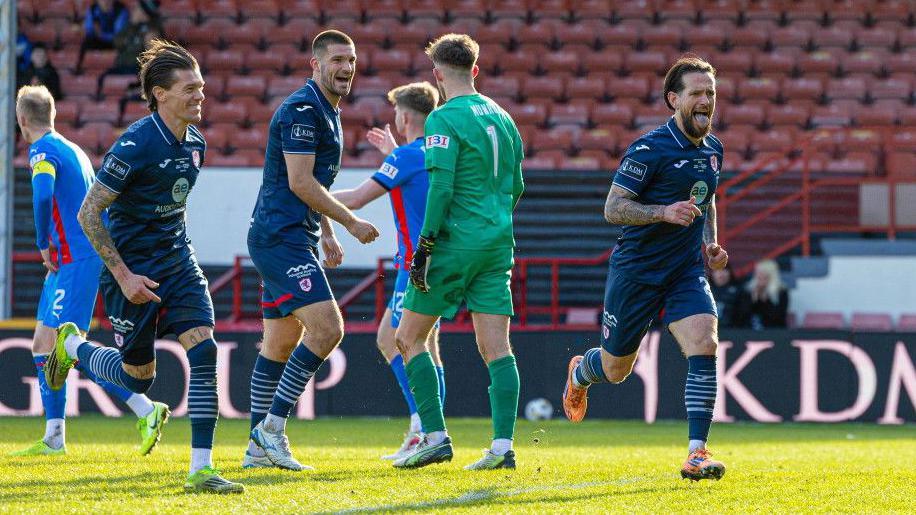 Dylan Easton a' dèanamh gàirdeachais às dèidh dha tadhal a chur 'son Raith Didòmhnaich an aghaidh ICT