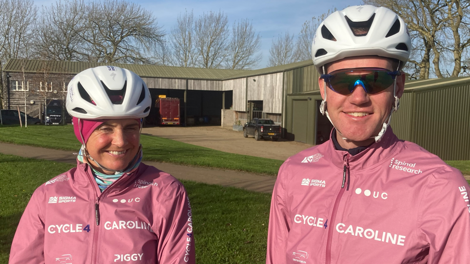 Piggy and Tom in cycle helmets - him with sunglasses - with both wearing pink cycling jackets with Cycle 4 Caroline in white lettering across the chest. Other logos in white are dotted around the chest area including Spinal Research and UC