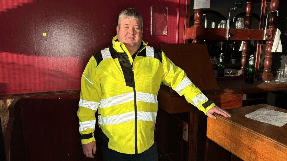 Daibhidh MacArtair ann am bàr an taigh-òsta.