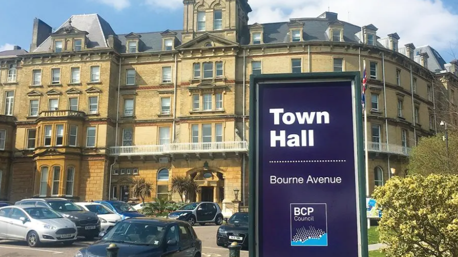 Picture shows a large BCP Council sign outside their Bournemouth town hall. Cars can be seen parked outside the council hq.