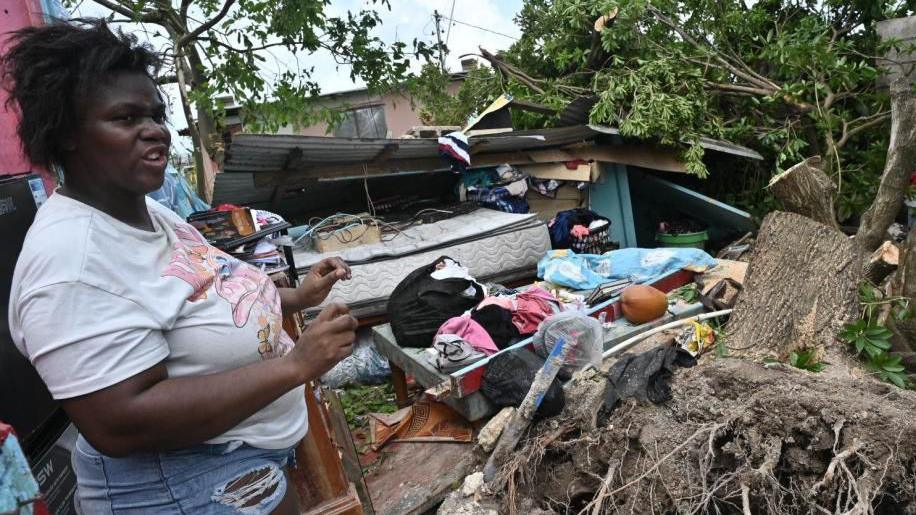 A woman looks at a house damaged by Hurricane Melissa in Saint Ann Parish in Middlesex County, Jamaica, 29 October 2025