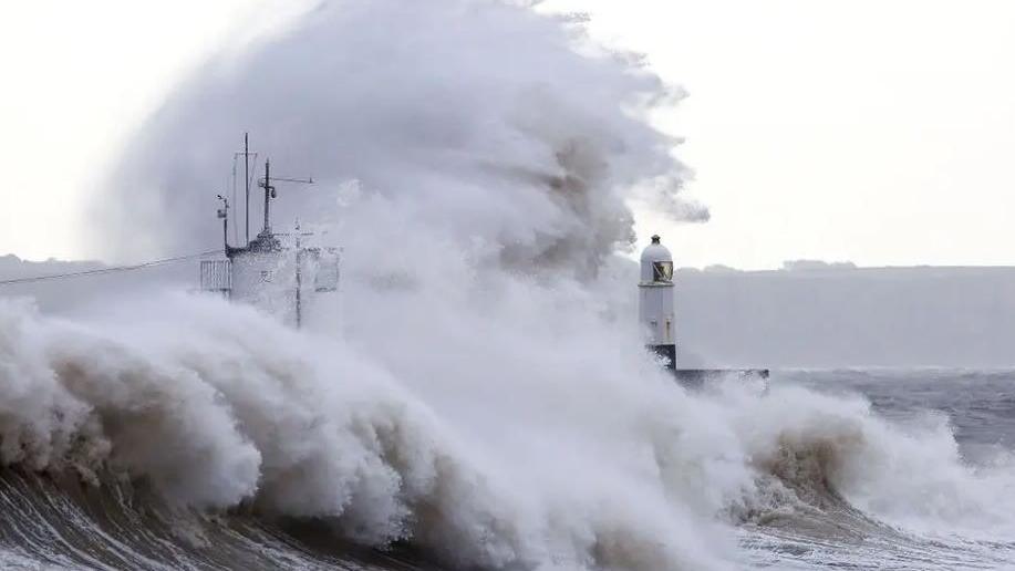 A large wave hits a harbour