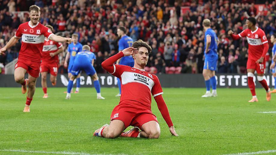 Hayden Hackney, on his knees with his hand raised to his head in salute, celebrates the goal in first-half that gave Middlesbrough a 2-1 lead over Birmingham City
