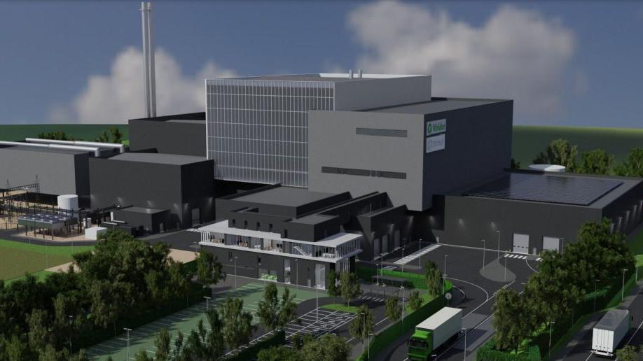 An image of what the new facility could look like. It shows several grey blocks with trees and parking outside. 