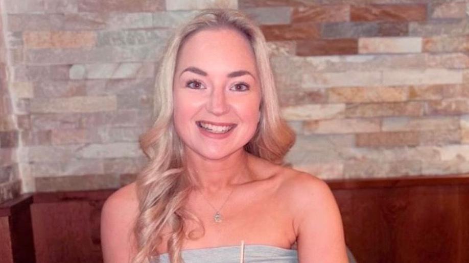 Rachel Smith in front of a slate wall wearing a grey top 