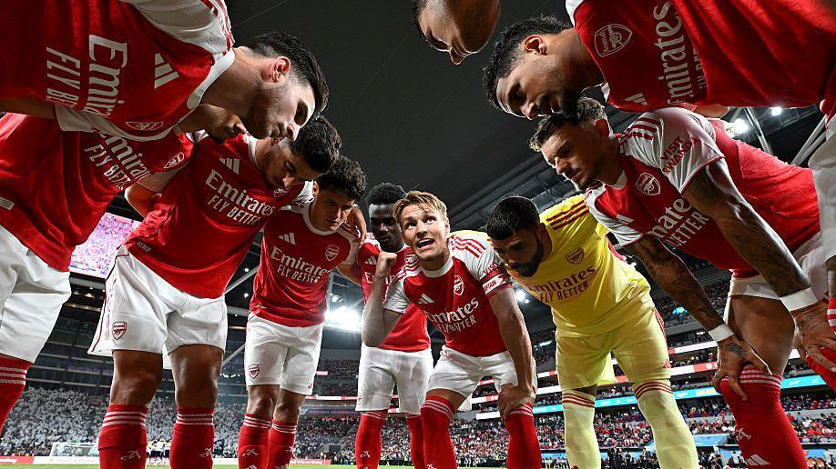 Arsenal players talk in a huddle