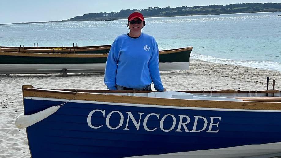 Klara Anstey standing next to the boat that will be used to cross the Atlantic